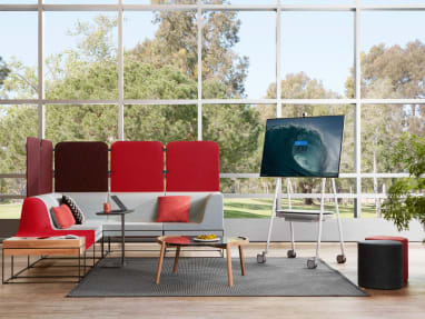 A Steelcase Roam Mobile Stand in a lounge area with Umami lounge seating and Bolia Mix coffee table
