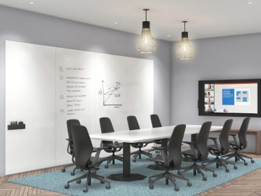 Conference room with large white table and SILQ chairs, on the wall there are 4 whiteboards