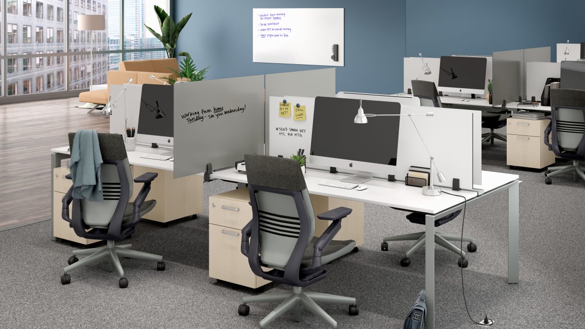 Office space with PolyVision Boundri™ screen dividers between individual workstations, black Gesture chairs and white desks.