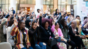 large group of women raising their hands